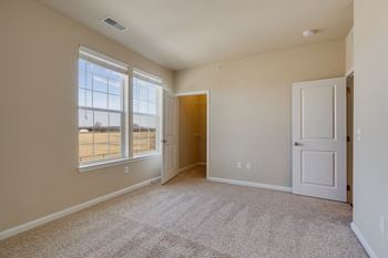 Carpeted Bedroom With Attached Walk-In Closet